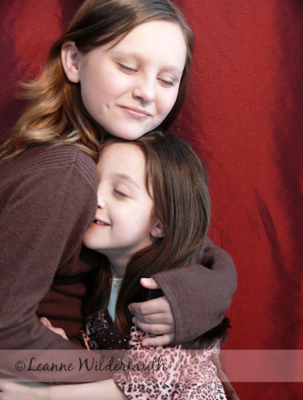 christmas photography sisterly love hug photo Leanne Wildermuth 2007' class=